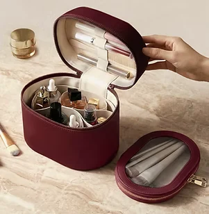 The vanity bag open, perfume bottles held upright inside.
